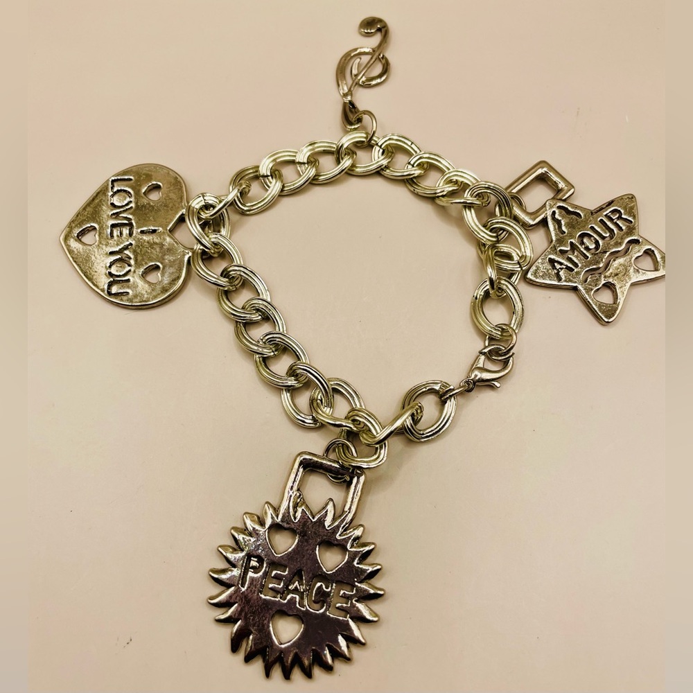 Charm bracelet with a heart, sun, star, and music note charms. 8 inches.